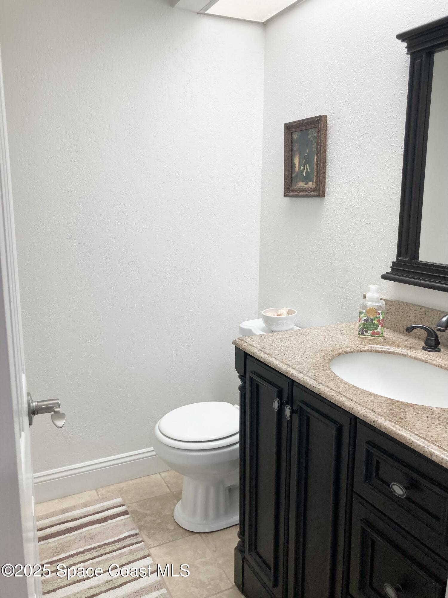 7 Cove Road Melbourne Beach, FL 32951 - Photo 7 of 55 a bathroom with a granite countertop sink and a mirror