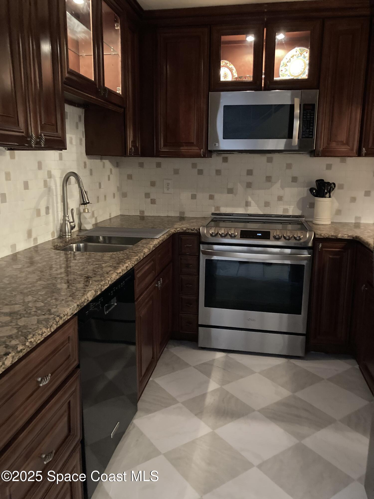 7 Cove Road Melbourne Beach, FL 32951 - Photo 10 of 55 a kitchen with stainless steel appliances granite countertop a stove microwave and sink