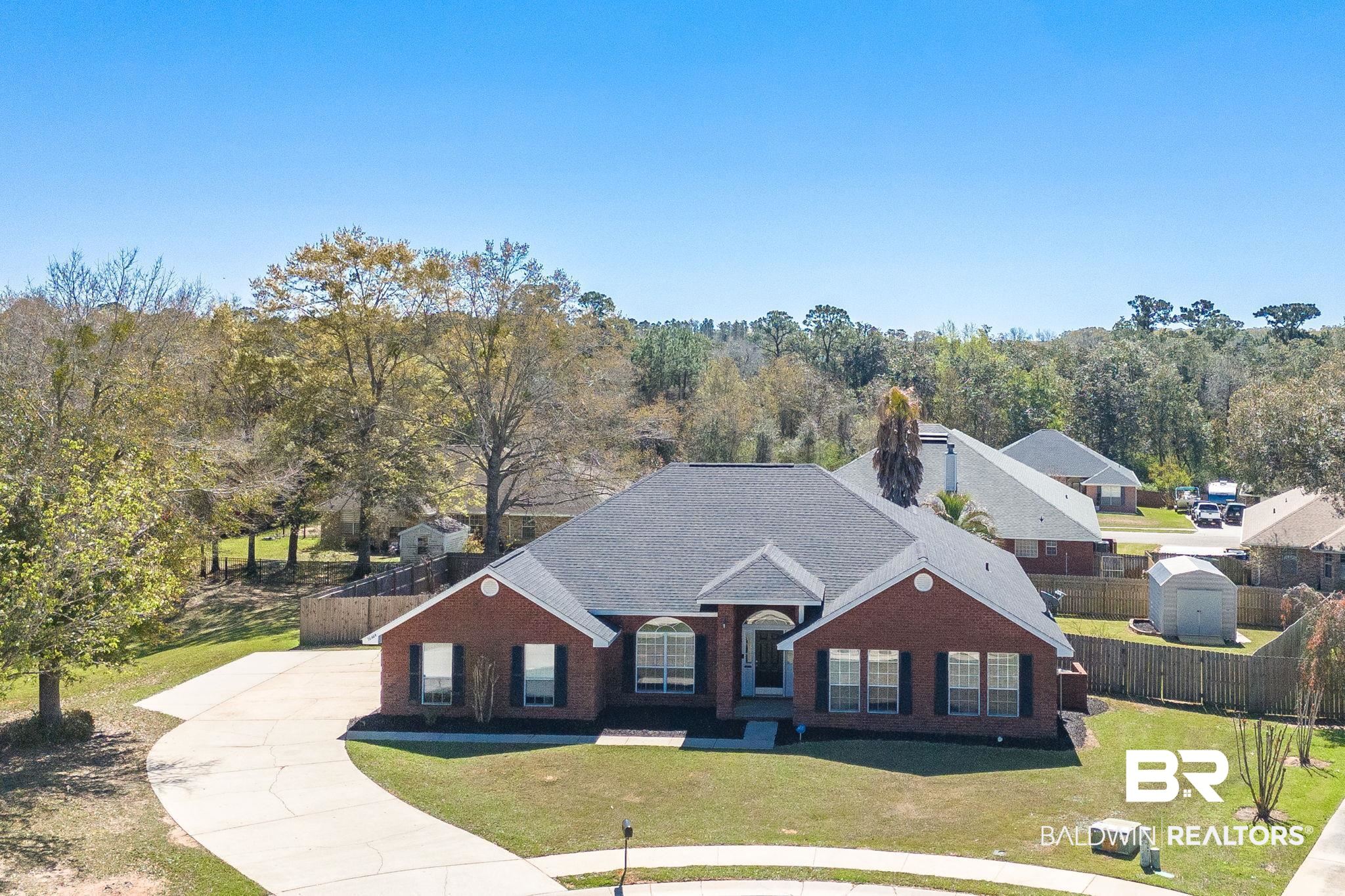 16444 Hamlet Lane Foley, AL 36535 - Photo 3 of 49 View of front of house with concrete driveway, roof with shingles, fence, a front yard, and brick siding