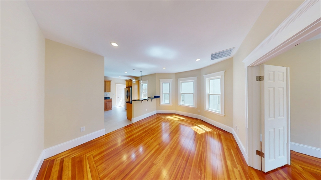 a view of a big room with wooden floor and windows