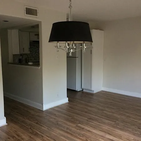 a view of a hallway with wooden floor and a cabinet