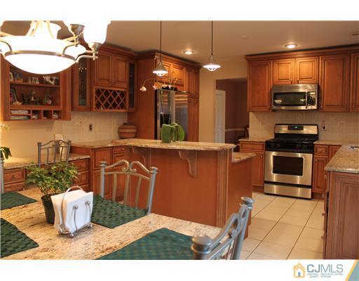 295 Marshall Road North Brunswick, NJ 08902 - Photo 6 of 19 a kitchen with stainless steel appliances kitchen island granite countertop a sink dishwasher stove and cabinets