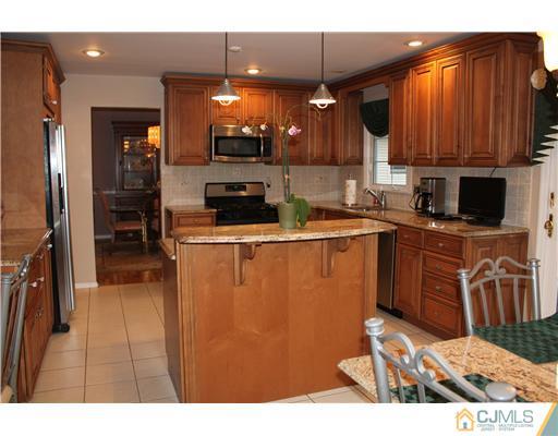 295 Marshall Road North Brunswick, NJ 08902 - Photo 7 of 19 a kitchen with stainless steel appliances kitchen island granite countertop a stove top oven a sink dishwasher and cabinets with wooden floor