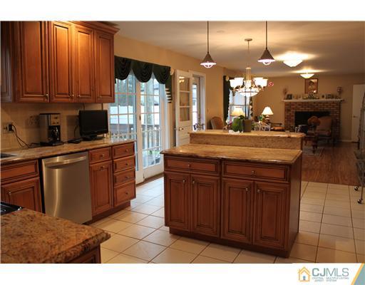 295 Marshall Road North Brunswick, NJ 08902 - Photo 8 of 19 a kitchen with kitchen island granite countertop wooden cabinets a stove and a sink