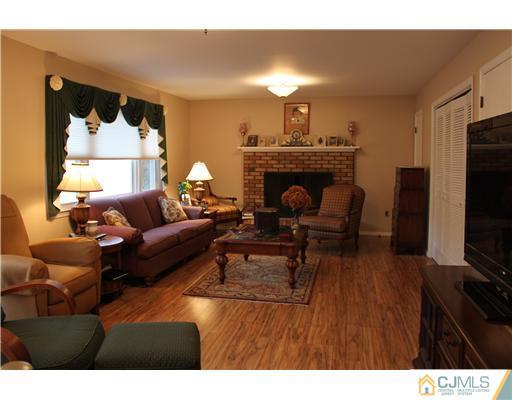 295 Marshall Road North Brunswick, NJ 08902 - Photo 9 of 19 a living room with furniture a fireplace and a flat screen tv