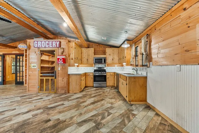 a kitchen with stainless steel appliances wooden cabinets a sink and a refrigerator