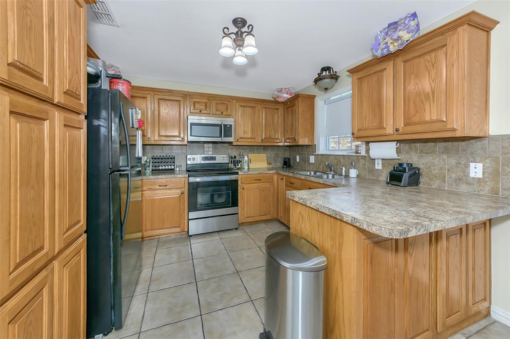 203 North Church Street Blue Ridge, TX 75424 - Photo 4 of 18 a kitchen with stainless steel appliances granite countertop a sink stove and refrigerator