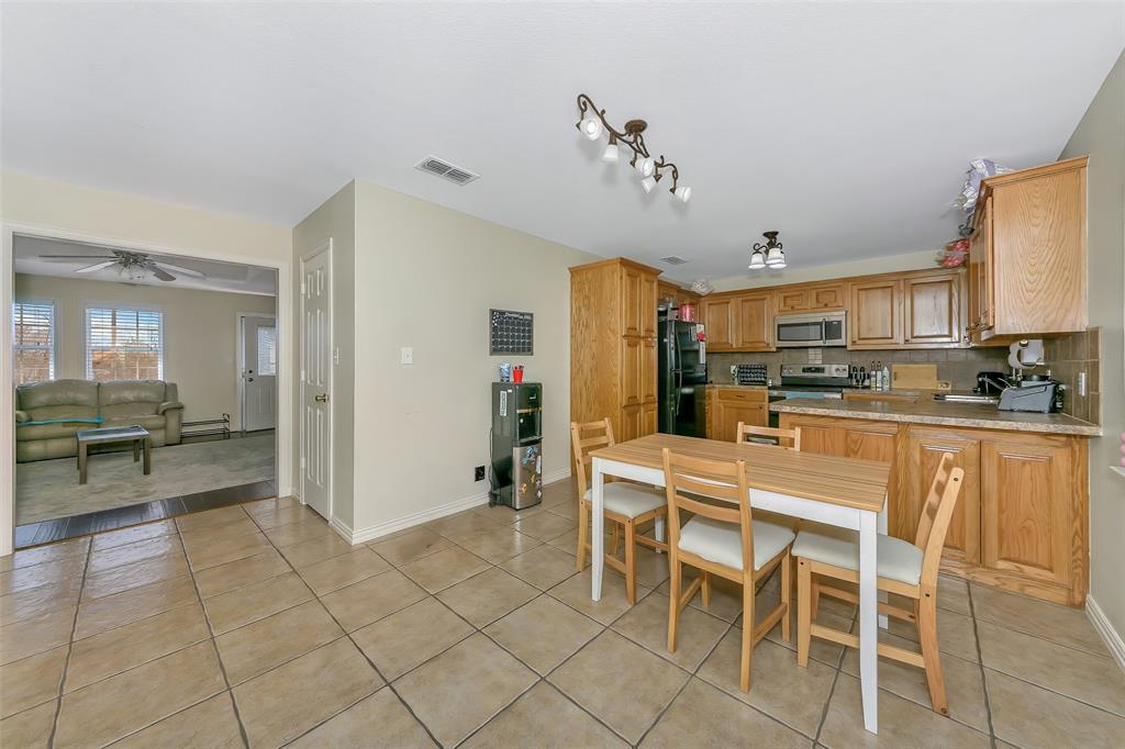203 North Church Street Blue Ridge, TX 75424 - Photo 5 of 18 a kitchen with stainless steel appliances kitchen island granite countertop a refrigerator and cabinets