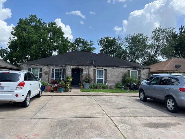 a front view of a house with a garden and trees