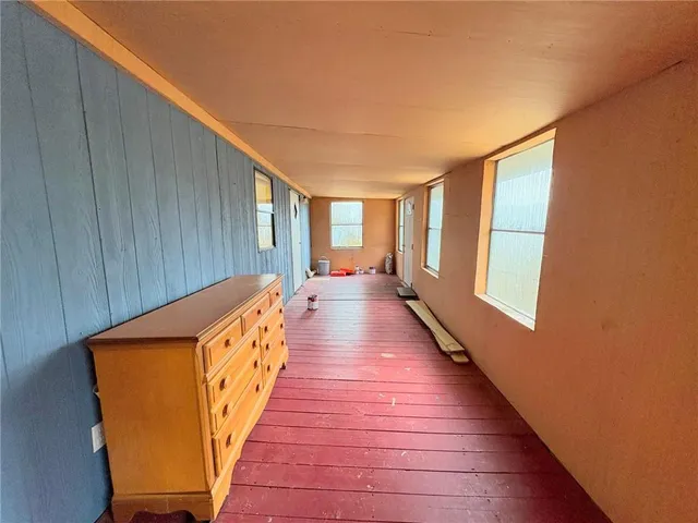 a hallway with wooden floor and furniture