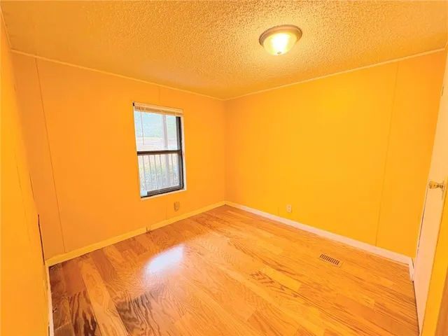 a view of a room with a wooden floor and a window