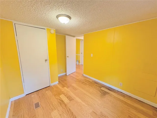 a view of a big room with wooden floor and windows