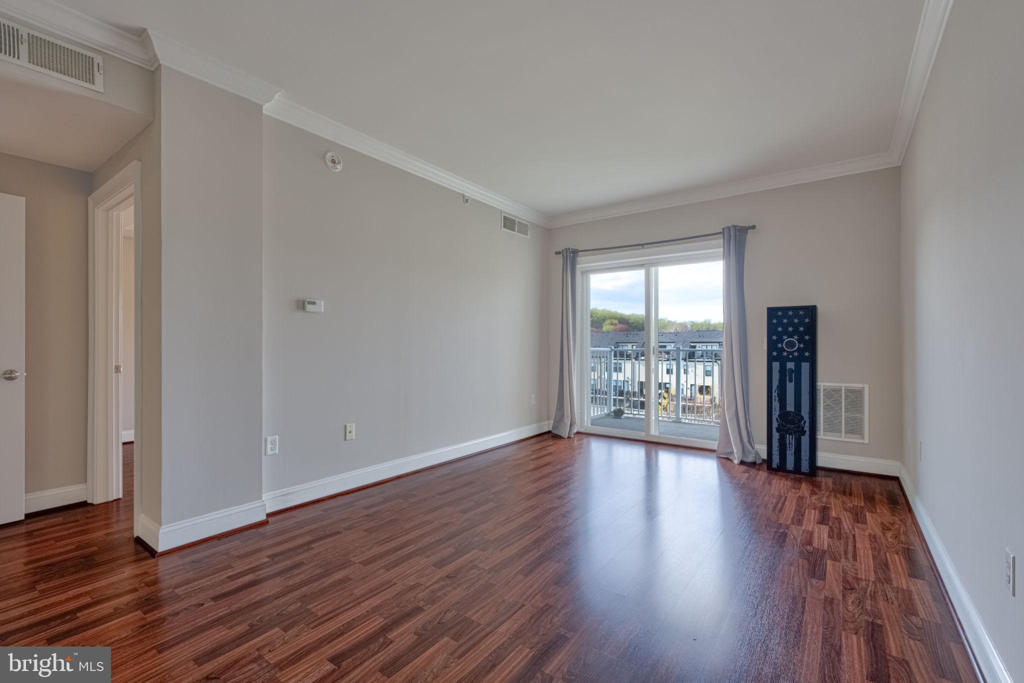6301 Edsall Road, Unit 418 Alexandria, VA 22312 - Photo 18 of 44 a view of an empty room with wooden floor and a window