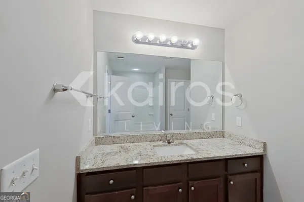 a bathroom with a granite countertop sink a mirror and a shower