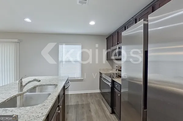 a kitchen with a refrigerator sink and cabinets