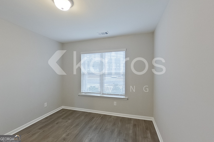 101 St Phillip Way Springfield, GA 31329 - Photo 8 of 25 an empty room with wooden floor and windows