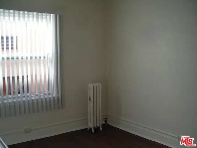 an empty room with wooden floor and a window