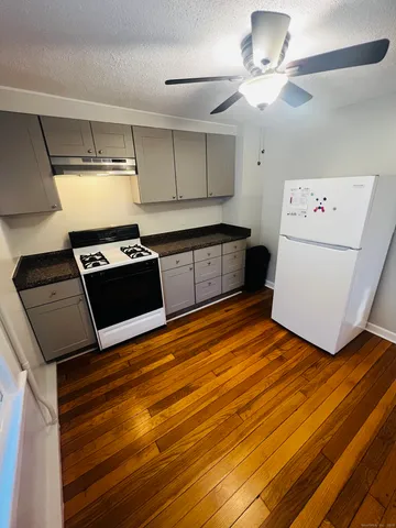 a kitchen with a stove cabinets and wooden floor