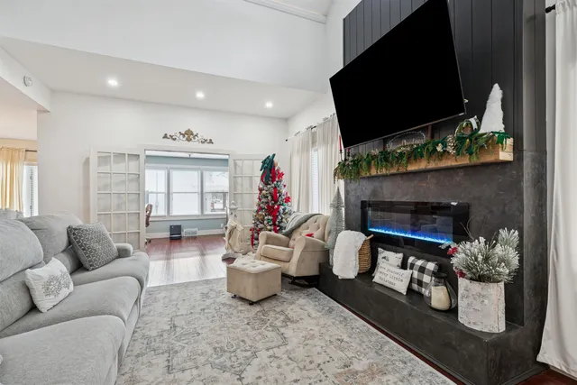 a living room with furniture a flat screen tv and a fireplace