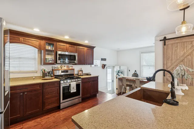 a kitchen with stainless steel appliances granite countertop a sink stove and refrigerator