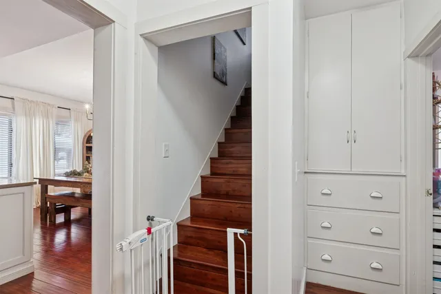 a view of a hallway with wooden floor and staircase