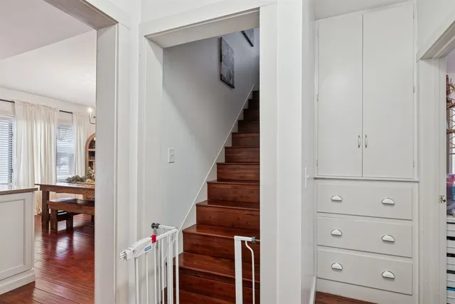 a view of a hallway with wooden floor and staircase
