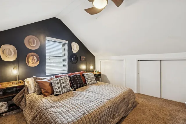 a bedroom with a bed and painting on the wall