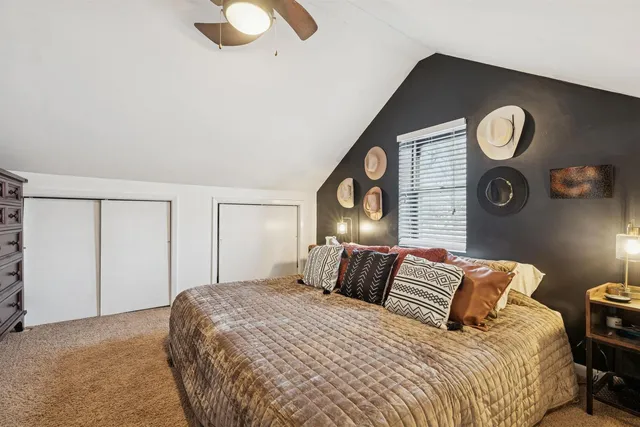 a bedroom with a bed and painting on the wall