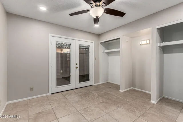 a view of an empty room with a chandelier fan
