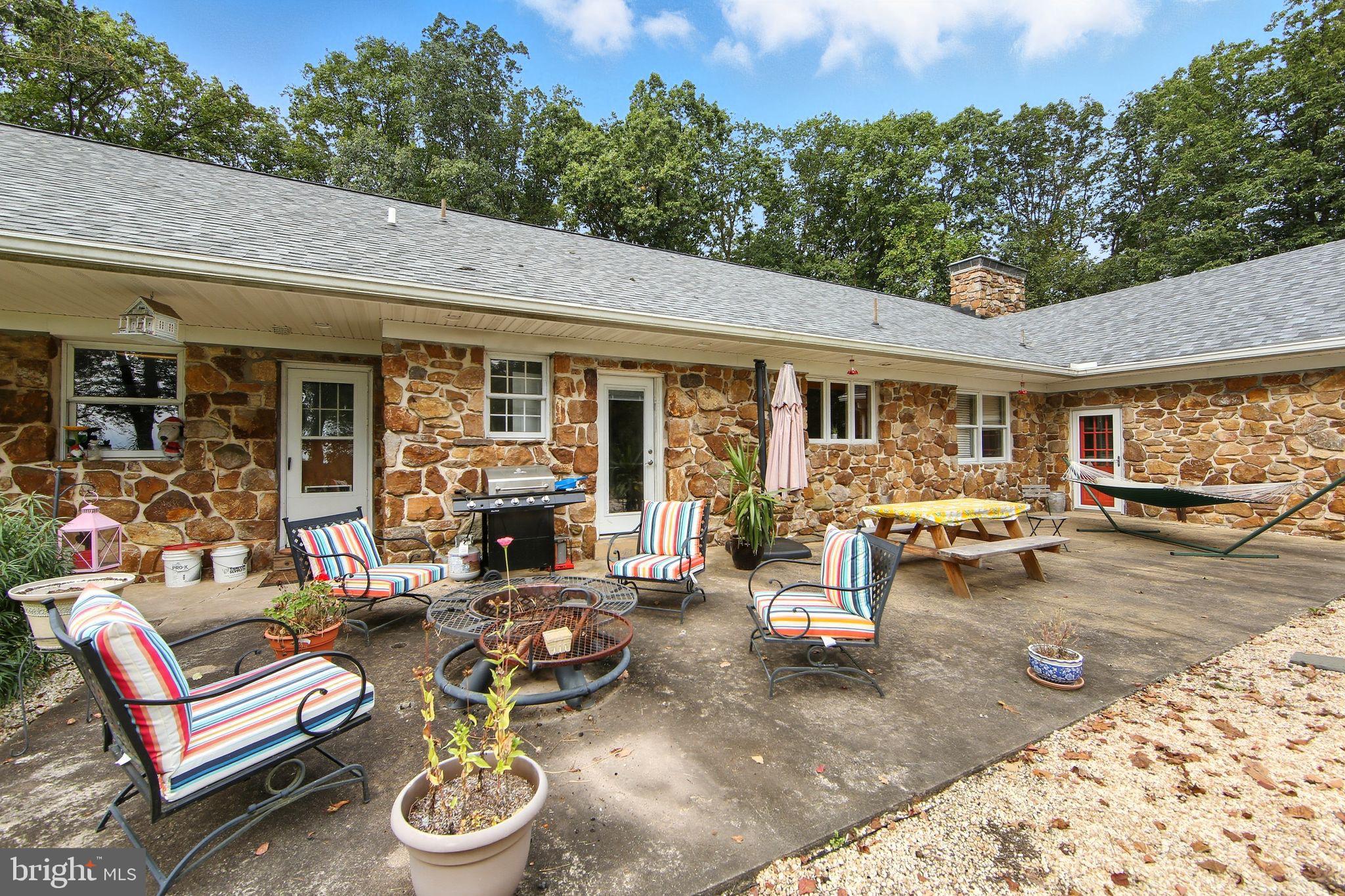 156 Grove Road Elverson, PA 19520 - Photo 39 of 45 a view of a patio with table and chairs potted plants and floor to ceiling window
