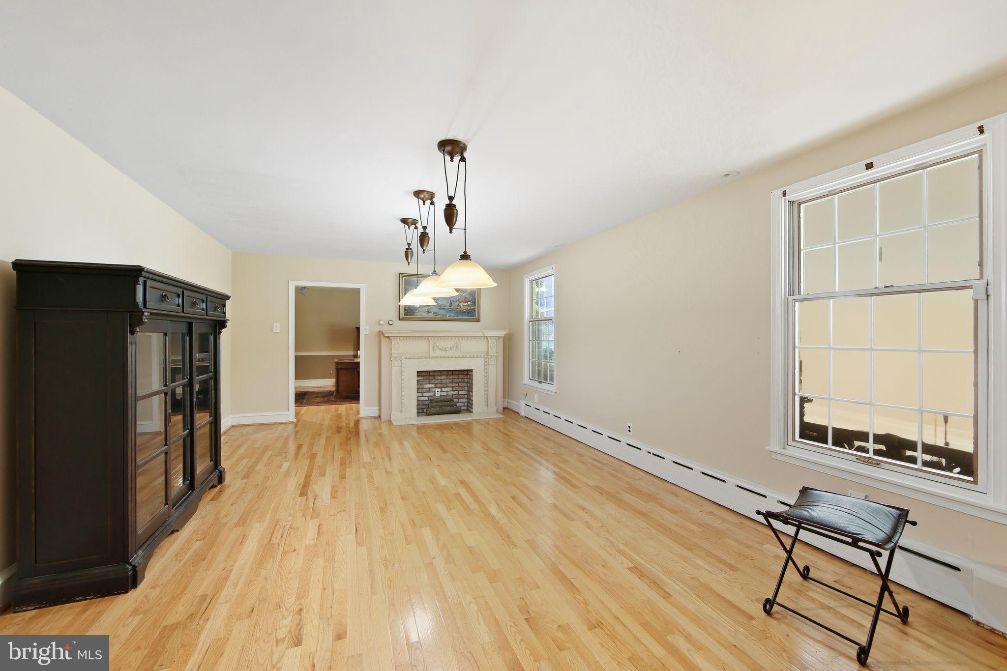 156 Grove Road Elverson, PA 19520 - Photo 9 of 45 a view of empty room with wooden floor and fireplace
