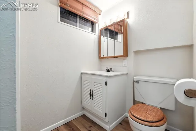 a bathroom with a toilet sink vanity and mirror