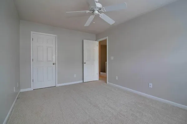 an empty room with chandelier fan