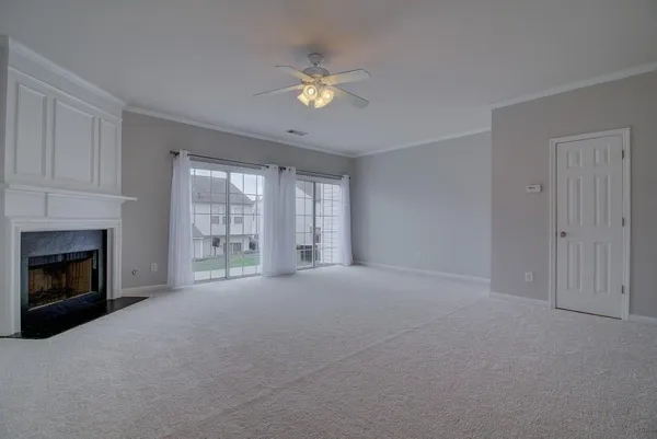 a view of an empty room with a fireplace and a window