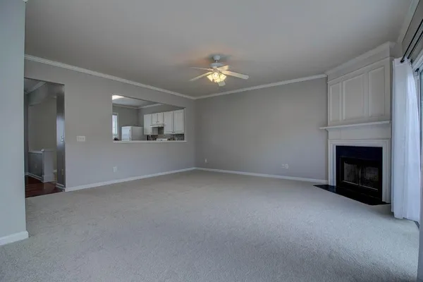 an empty room with a fireplace and fan