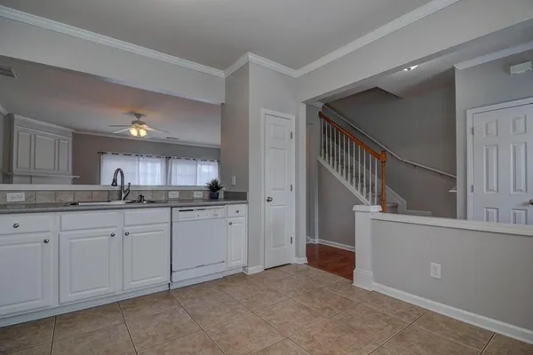 a kitchen with white cabinets and sink