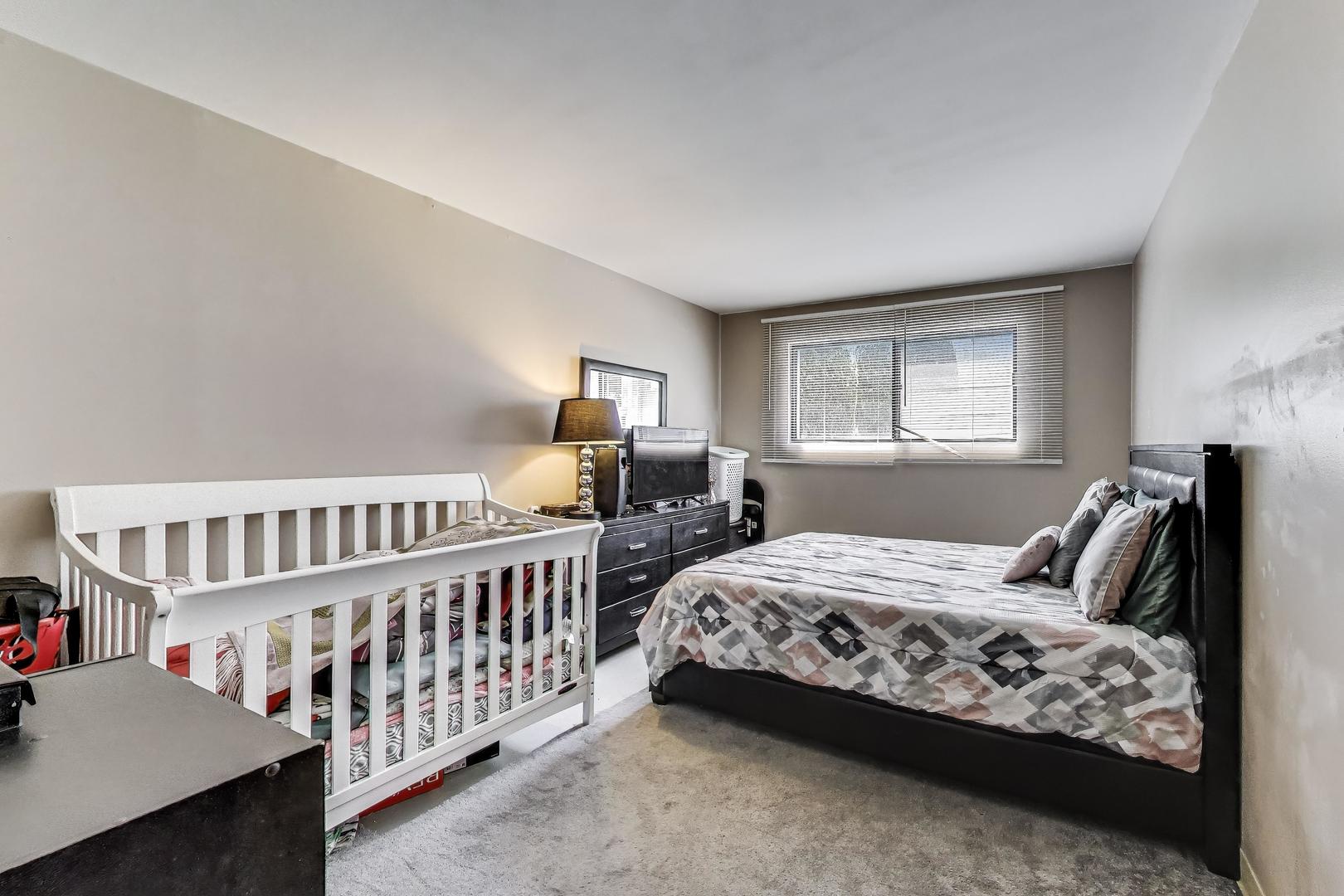 5113 North East River Road, Unit 1M Chicago, IL 60656 - Photo 14 of 25 a bedroom with furniture and a window