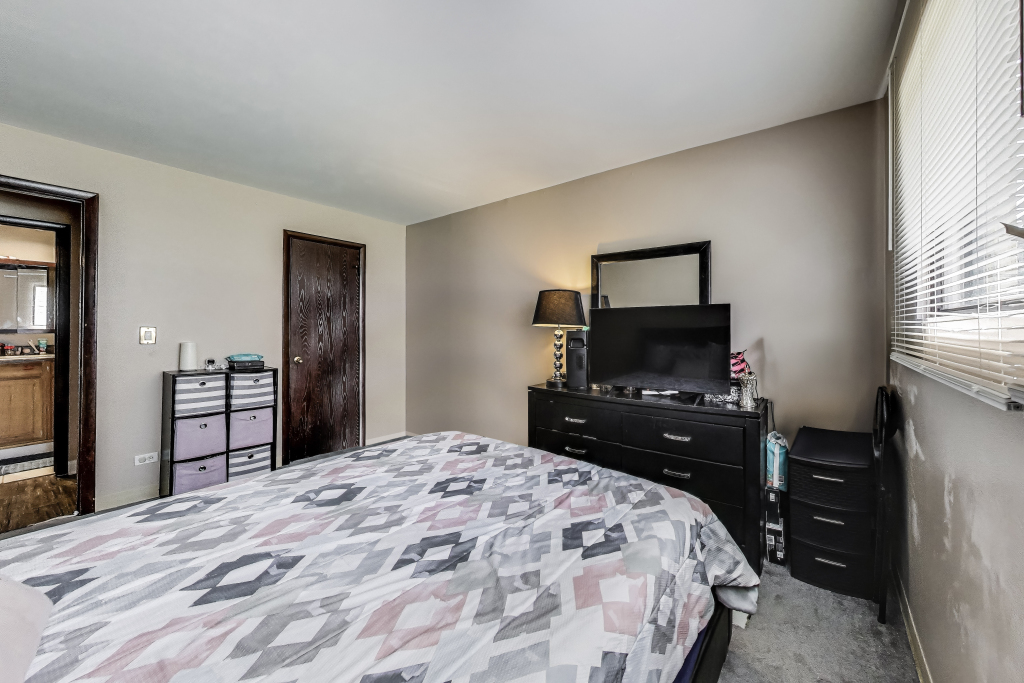 5113 North East River Road, Unit 1M Chicago, IL 60656 - Photo 18 of 25 a bedroom with a bed and a flat screen tv