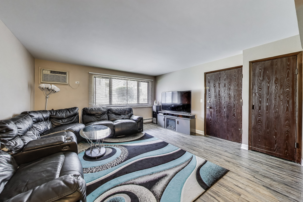 5113 North East River Road, Unit 1M Chicago, IL 60656 - Photo 19 of 25 a living room with furniture and a flat screen tv