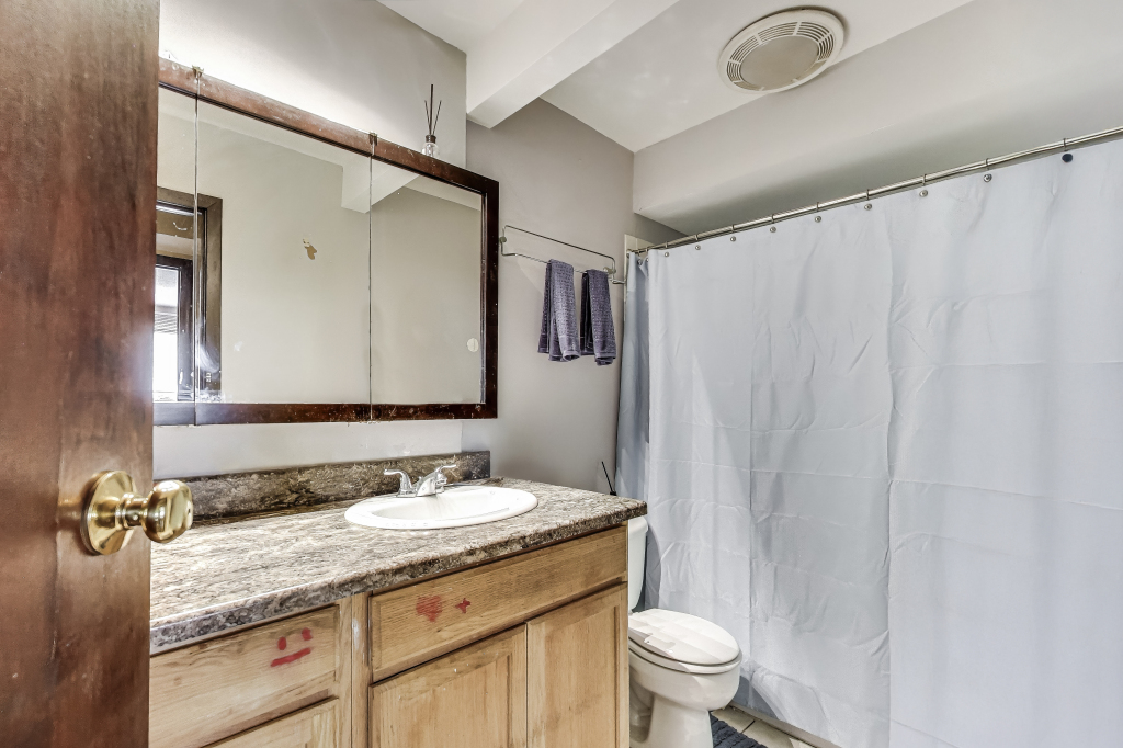 5113 North East River Road, Unit 1M Chicago, IL 60656 - Photo 22 of 25 a bathroom with a granite countertop sink a toilet and a mirror