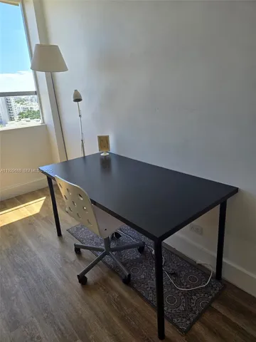 a living room with table chairs and a window