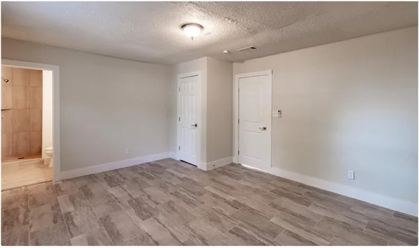 a large kitchen with kitchen island granite countertop a stove top oven a sink a counter space and cabinets