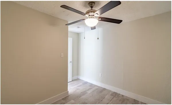 a view of a hallway with a closet and a ceiling fan