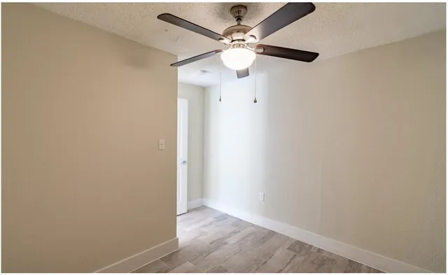 a view of a hallway with a closet and a ceiling fan