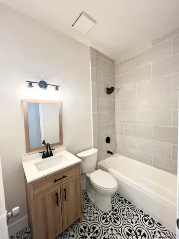 a bathroom with a sink a toilet and shower
