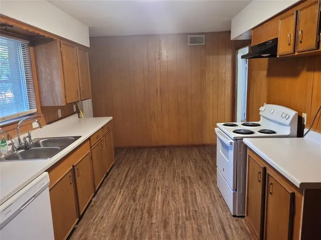 a view of a kitchen with a sink and wooden floor