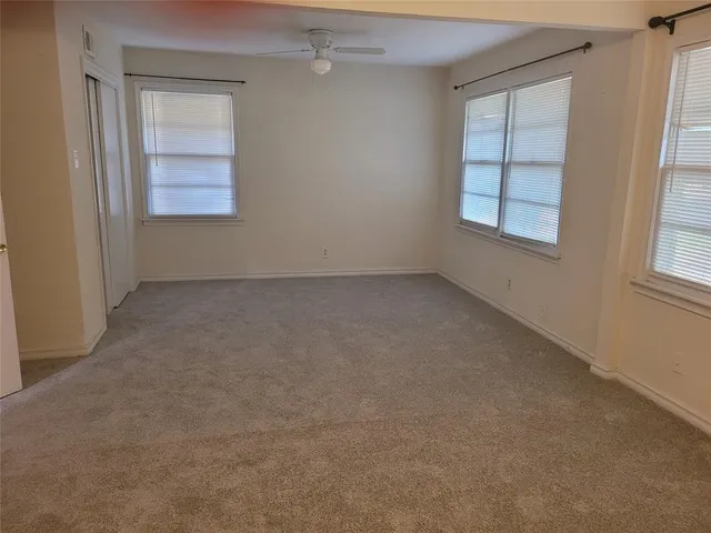 an empty room with windows and closet