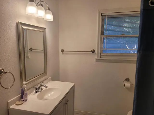 a bathroom with a sink vanity and mirror