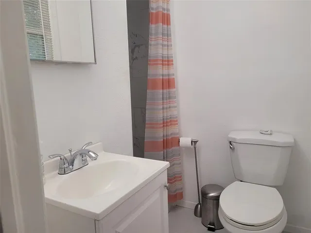 a white toilet sitting next to a bathroom sink