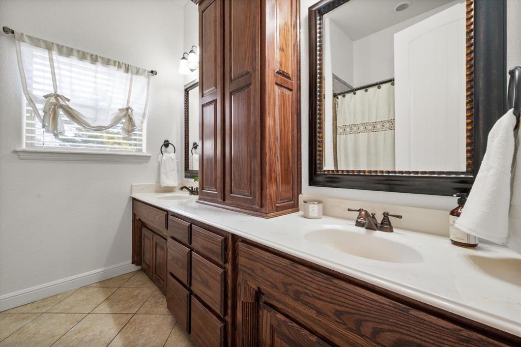 3840 Angela Court Midlothian, TX 76065 - Photo 27 of 40 a bathroom with a double vanity sink window and a mirror